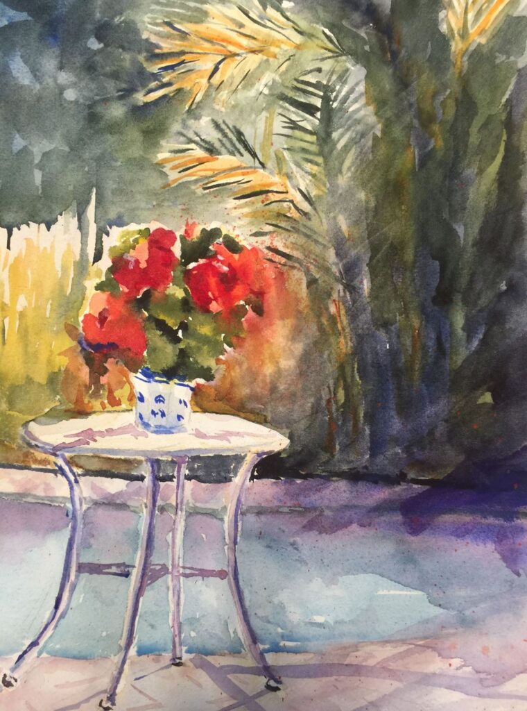 The Seymour Cafe by Poolside, original watercolor painting of a table with red flowers on it with water and bushes in the background