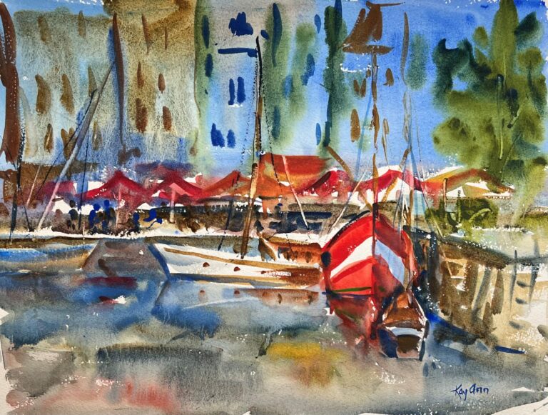 Honfleur Harbor, original watercolor painting of a red boat. The harbor is surrounded by many colorful umbrellas and people eating at tables. There are various colors of buildings and also a blue boat and a white boat.