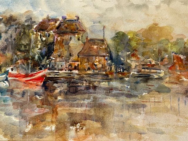 Le Vieux Bassin, original watercolor painting of a town on the waters edge. There are a couple of boats in the water in front of the buildings and a few trees among the buildings. The coloring is brownish and tan predominantly with a red boat and some greyish reflections in the water.